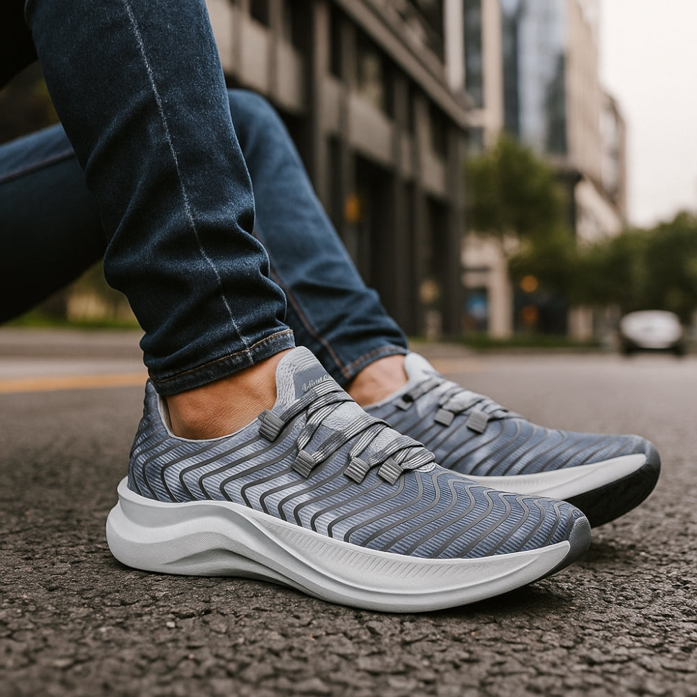 Gray athletic shoes worn on a city street with blurred background