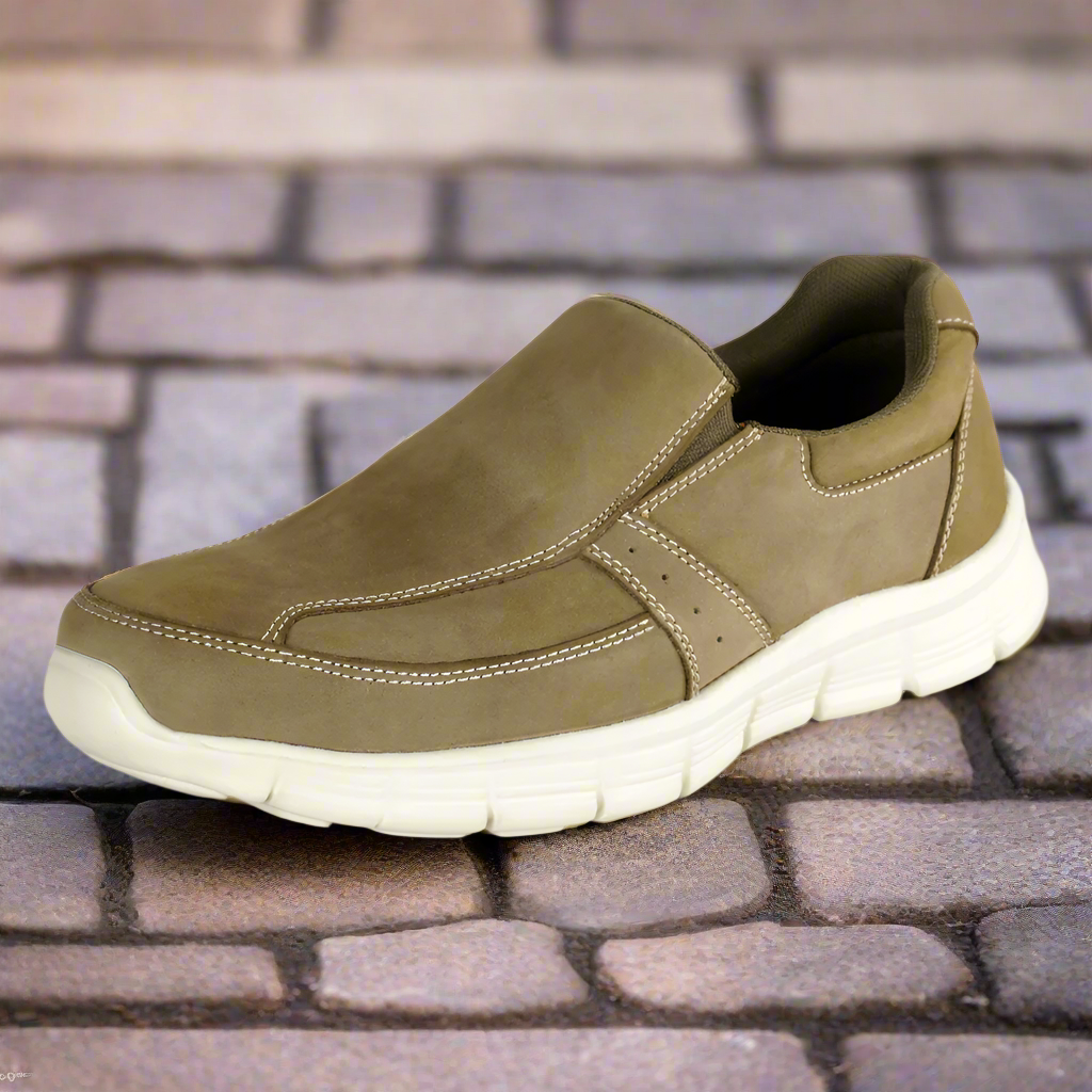 A single olive green casual shoe for men displayed on a cobblestone surface.