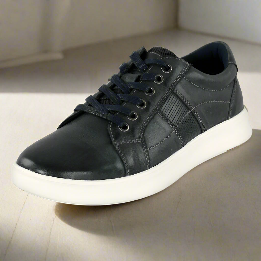 Black leather sneaker with white sole on a white background