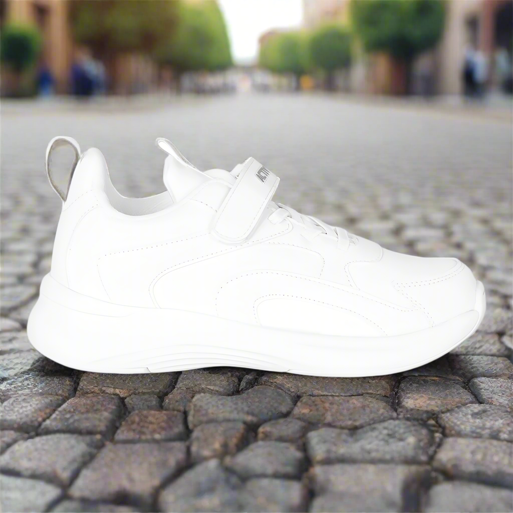 White sneaker on a textured pavement with a blurred street background