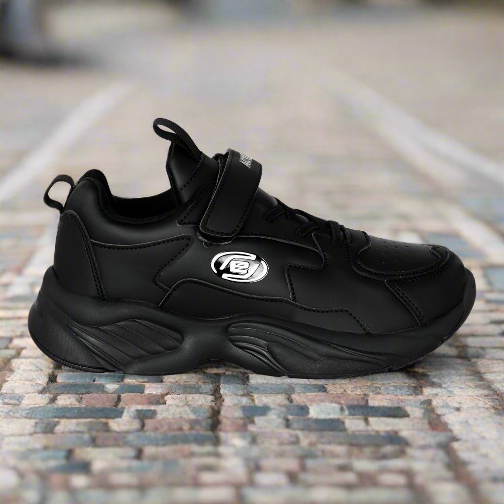 Black sneaker with a brand logo on a mosaic tile floor