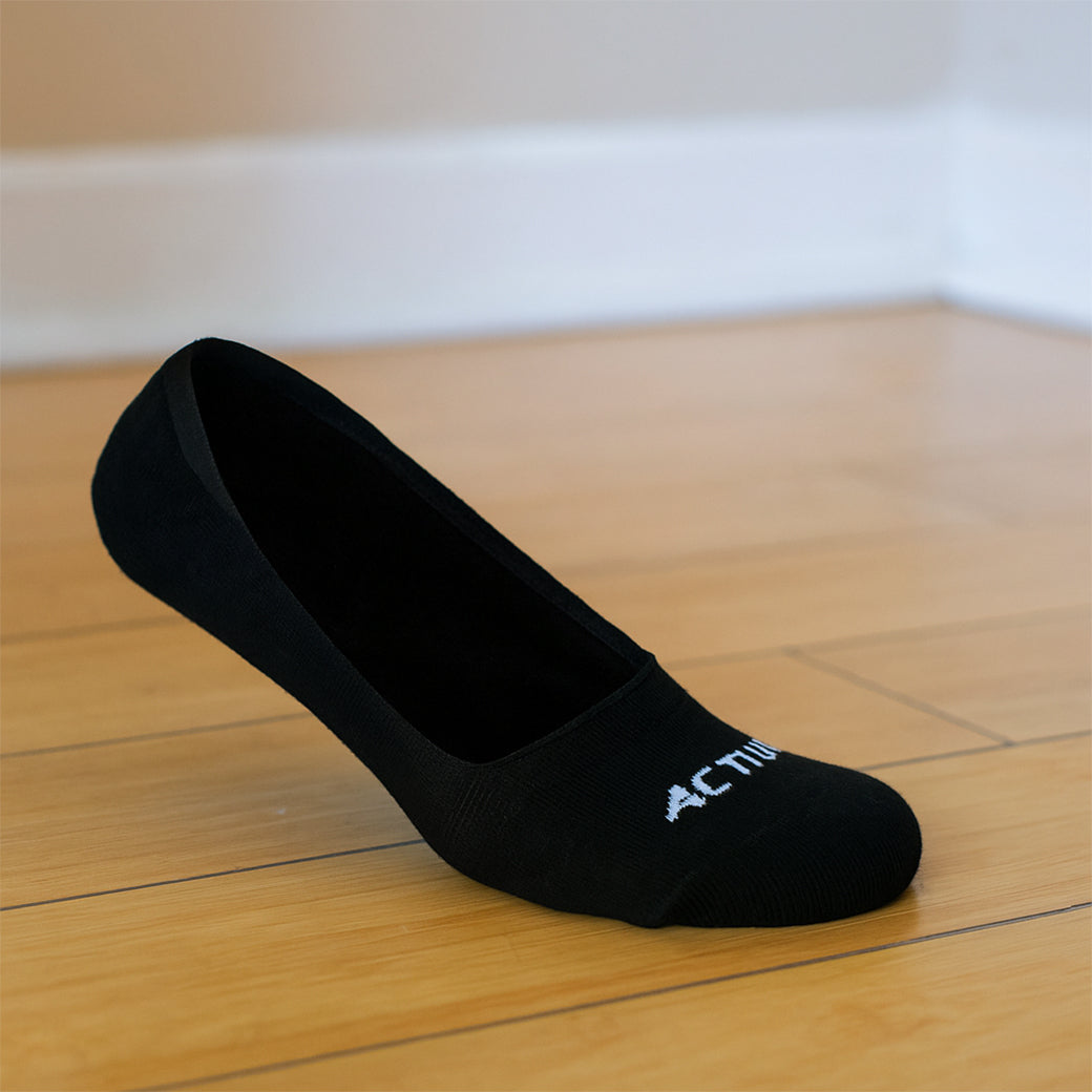 Black sock with 'Activia' branding on a wooden floor