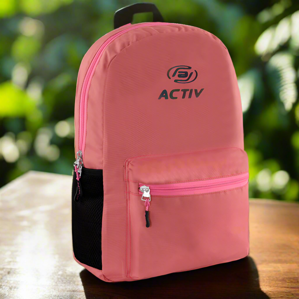 Pink backpack with 'ACTIV' branding on a wooden surface with a blurred green background